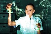 stock photo of team  - Young chemist in white uniform working in laboratory - JPG 