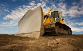 foto of construction  - A large yellow bulldozer at a construction site low angle view - JPG 