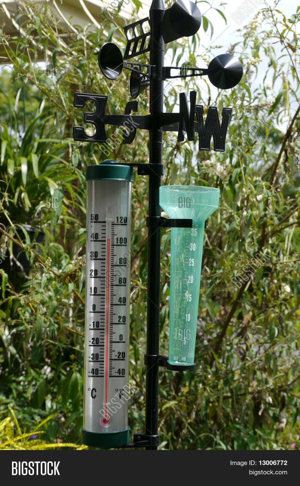 Garden thermometer, rain gauge and weather vane Stock Photo & Stock