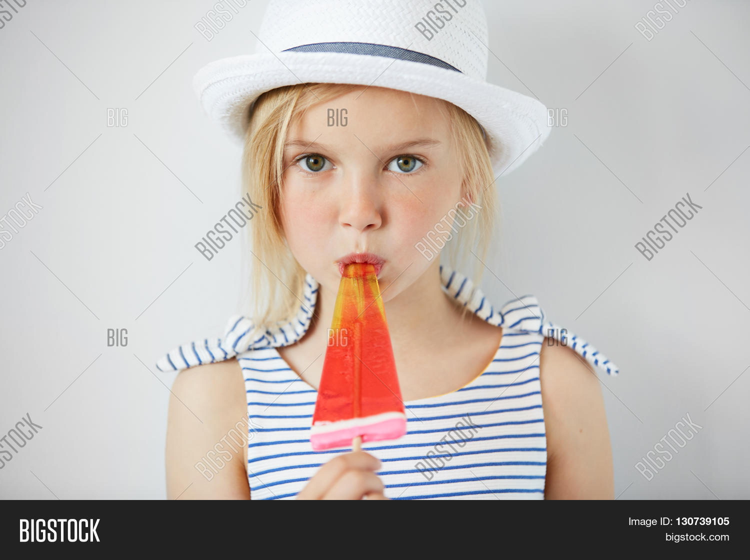 Isolated Shot Of Cute Little Girl With Green Eyes And Blonde Hair Isolated Shot Of Cute Little Girl With Green Eyes And Blonde Hair Wearing White Hat