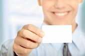 foto of business  - Young happy smiling successful business man with blank business card or sign - JPG 