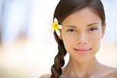 stock photo of multicultural  - Woman natural beauty portrait of a beautiful and smiling brunette smiling outdoors with a flower in her braided hair - JPG 