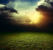 stock photo of clouds  - Storm dark clouds over field with grass - JPG 
