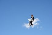 picture of business concept  - Asian business woman sit on cloud and use laptop over blue sky - JPG 