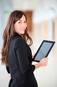 stock photo of newspaper  - Businesswoman standing in hall with electronic pad - JPG 