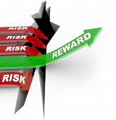 pic of investment  - The word Reward on an arrow rising over a hole while others with Risk words fall into the pit to illustrate loss from a bad investment - JPG 