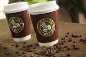 picture of objects  - Two paper cup of coffee to go on a table with coffee beans - JPG 