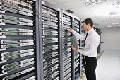 stock photo of isp  - young handsome business man engeneer in datacenter server room - JPG 