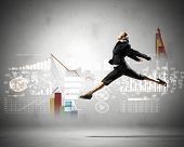 picture of venture  - Image of pretty businesswoman jumping high against financial background - JPG 