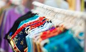 image of trade  - Rows of new colorful clothing on hangers at shop in foreground and background - JPG 