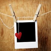 image of  photo  - Blank instant photo and small red paper heart hanging on the clothesline - JPG 