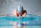 foto of competition  - woman swims using the breaststroke in indoor pool - JPG 
