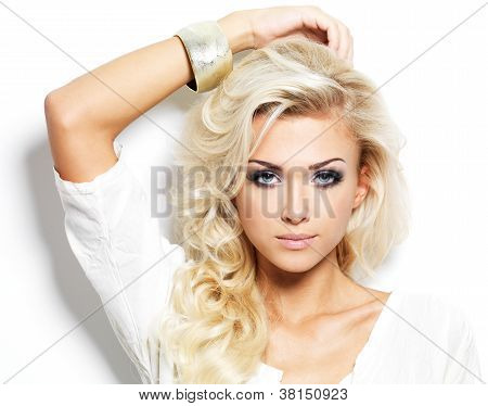 Picture or Photo of Beautiful blond woman with long curly hair and style makeup. Girl posing on white background