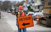 image of construction worker  - road construction worker holding a detour sign and gesturing to stop - JPG 