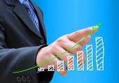 stock photo of money  - businessman hand pushing a business graph on a touch screen interface - JPG 