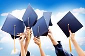 stock photo of group  - Unrecognizable group of people throwing graduations hats in the air - JPG 