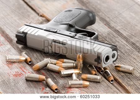 Poster: Handgun With Scattered Bullets And