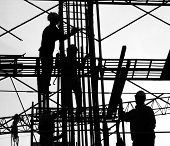 stock photo of construction worker  - construction workers silhouette high up on the scaffolding - JPG 