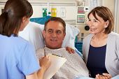 stock photo of talking  - Nurse Talking To Couple On Ward - JPG 