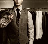 stock photo of businessmen  - Businessman in classic vest against row of suits - JPG 