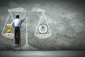 picture of objects  - Businessman on ladder pointing at scale picture - JPG 