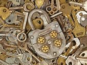 stock photo of locking  - Old lock on a lot metal keys background taken closeup - JPG 