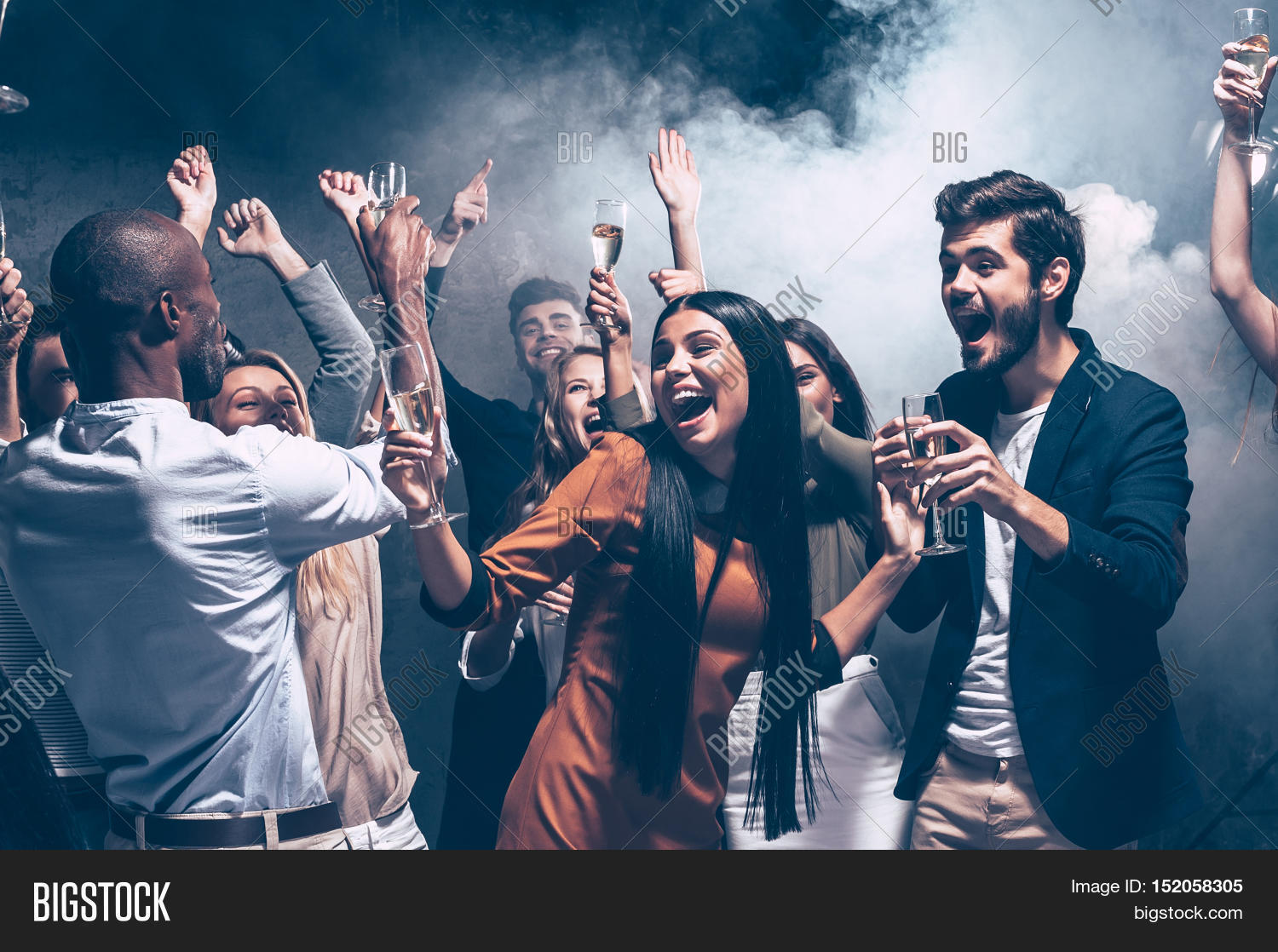 group of beautiful young people dancing with champagne flutes