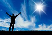 image of religion  - Silhouette of man with hands raised to a bright star in the sky - JPG 