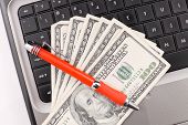 foto of currency  - Online Marketing and Business concept with red pen on cash currency on computer - JPG 