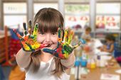 image of kindergarten  - Happy Girl Painting With Her Hands in Kindergarten Class - JPG 