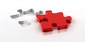 picture of puzzle  - A red piece of a jigsaw puzzle fitting in the hole on the bottom - JPG 