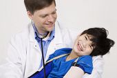 picture of medical doctors  - Male doctor in early forties holding five year old disabled patient during office visit - JPG 