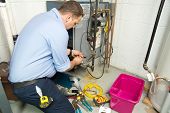 image of wire  - Plumber fixing gas furnace using electric and plumbing tools - JPG 