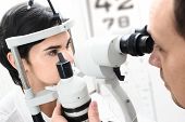 image of medical  - Beautiful young female patient is having a medical attendance at the optometrist - JPG 