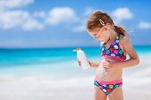 pic of beach  - Adorable little girl at tropical beach applying sunblock cream - JPG 