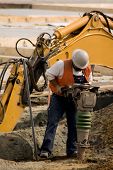 picture of construction worker  - A construction worker using a large soil tamping machine - JPG 