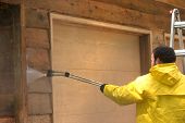 picture of pressure  - a man pressure washing a wood sided garage - JPG 