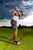 picture of golf  - Young golf player on course doing golf swing - JPG 