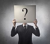 image of businessmen  - Young businessman holding a white billboard with a question mark on it - JPG 