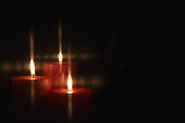 foto of religion  - Closeup of burning candles isolated on black background - JPG 