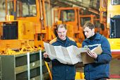 image of industrial  - adult experienced industrial workers examining technical drawing during heavy industry machinery assembling on production manufacturing line - JPG 