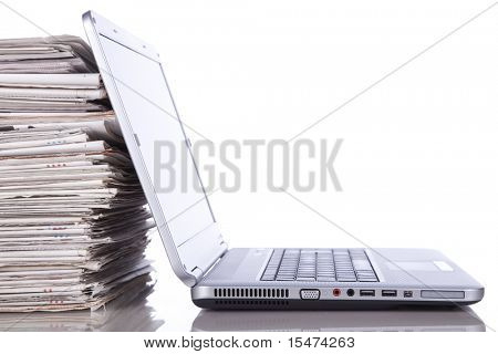 Picture or Photo of Stack of newspaper next to a laptop (isolated on white)