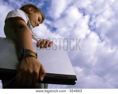Picture or Photo of The child with a portable computer in the blue sky.