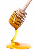 picture of drip  - Honey dripping from a wooden honey dipper on white background - JPG 