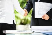 foto of handshake  - Handshake between businessman and businesswoman in a meeting - JPG 