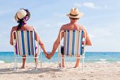 stock photo of beach  - Relaxed summer vacation senior couple of old man and woman sitting on the beach - JPG 