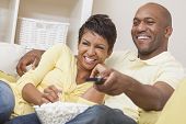 stock photo of man  - A happy African American man and woman couple in their thirties sitting at home - JPG 
