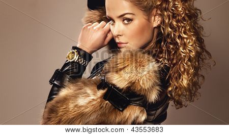 Picture or Photo of Portrait of beautiful young girl wearing fashionable fur and watch looking at camera.