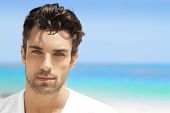 pic of nature  - Handsome young man in casual white top against bright beach background - JPG 