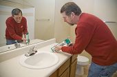 picture of seep  - Contractor caulking around toilet to keep moisture from seeping - JPG 